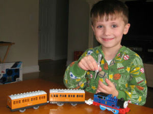 Thomas adding water to his Thomas steam train